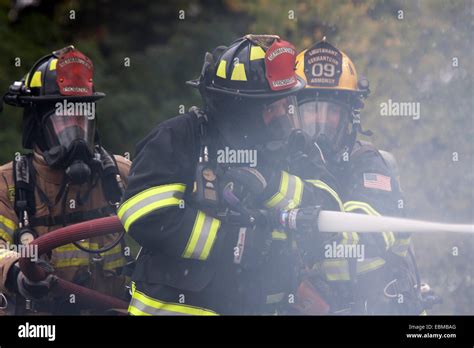 Three Firefighters Putting Out A Fire Stock Photo Alamy