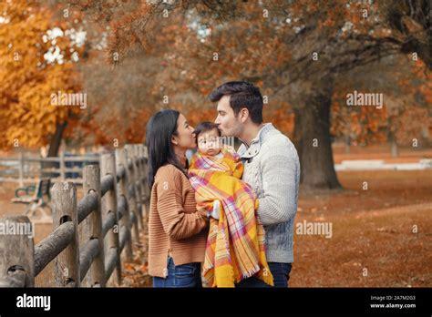 Asian Chinese Mother And Caucasian Father Dad Holding Kissing Baby Girl