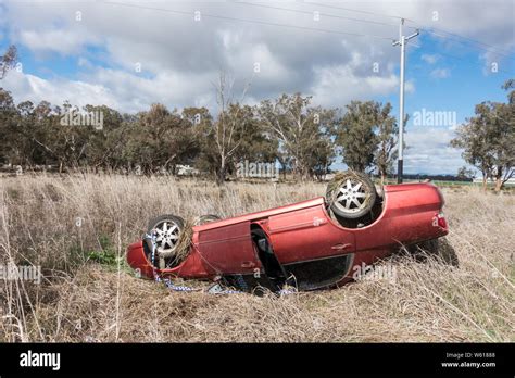 Red Car In Roll Over Accident On Country Road Australia Stock Photo