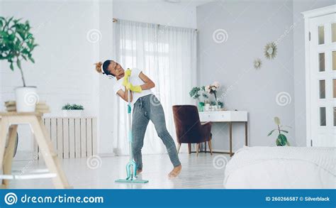 Happy African American Woman Is Washing Floor With Plastic Mop Singing