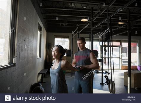 Man Stretching Womans Arms At Gym Stock Photo Alamy