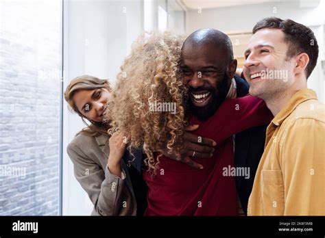 Happy Business People Hugging In Office Stock Photo Alamy