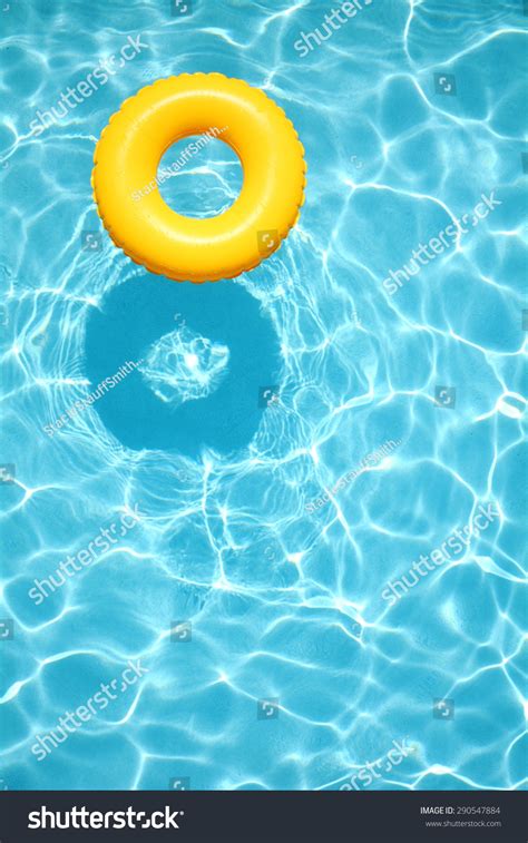 Yellow Pool Float Ring Floating In A Refreshing Blue Swimming Pool