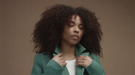 Mixed Race Black Woman In Green Coat In Beige Background With Huge Curly Afro Hair — Stock Video