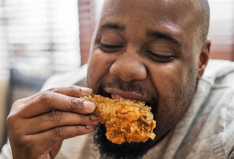 Free Photo Man Eating A Piece Of Fried Chicken
