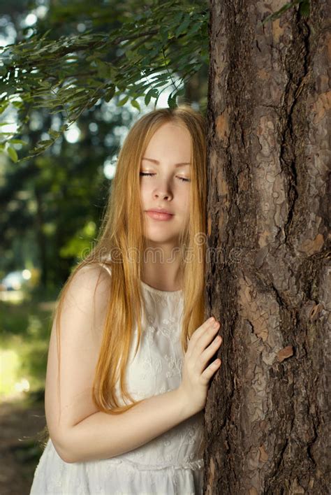 A Young Girl With Long Blond Hair Standing In The Forest Stock Image