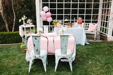 A Table Set Up With Pink And White Chairs
