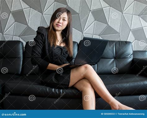 Beautiful Young Asia Business Woman Sitting On Sofa Working With Laptop Computer And Wear Black