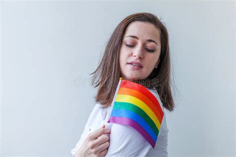 vacker kaukasisk lesbisk flicka med lgbt regnbågflagga på vit bakgrund som ser glad och