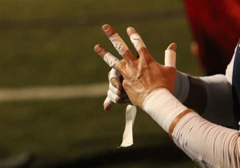 A Soccer Goalies Hands Are Seen Wrapped In White Athletic Tape As Are