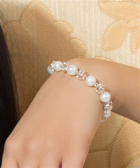 Brăţară din perle de sticlă albe cu noduri metalice