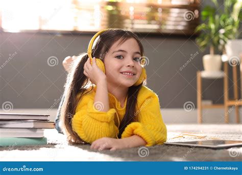 Cute Little Girl With Headphones Listening To Audiobook Stock Image
