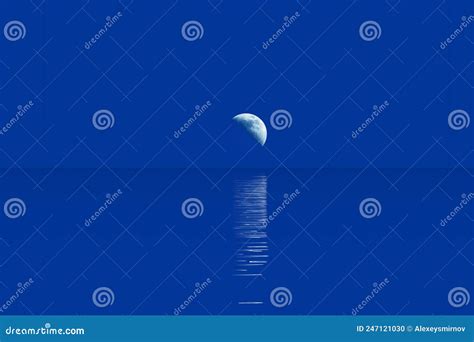 Crescent Moon Over Horizon And Moonlight Path In Water Surface Stock