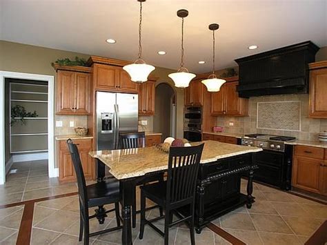 In traditional kitchens, the main focus is typically on the cabinets, countertops, and backsplash. Oak cabinets with black island and stove, tile floors ...