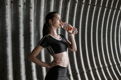 Premium Photo Fitness Model Drinking Water From Bottle After Running