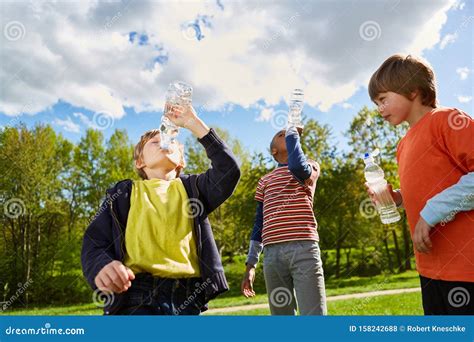 Children In The Park Drink From Water Bottles Stock Photo Image Of