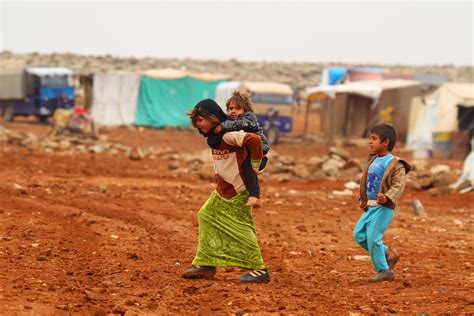An Internally Displaced Syrian Youth Carries A Baby On Her Back Inside