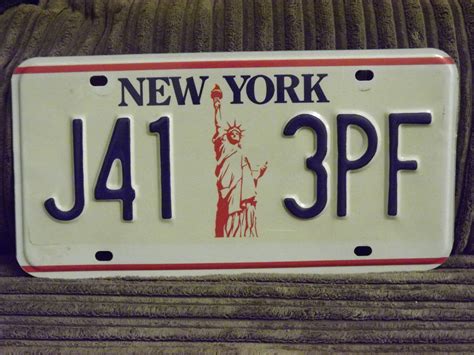 A New York License Plate With The Statue Of Liberty On It