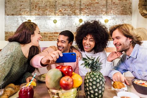 Happy Diverse Friends Taking Selfie In Restaurant By Stocksy Contributor Victor Torres Stocksy