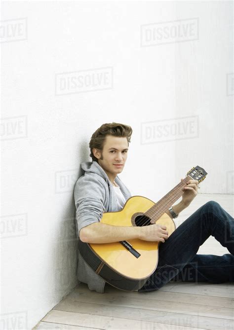 Young Man Sitting On Floor Playing Guitar Stock Photo Dissolve