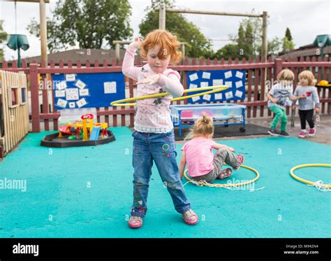 Nursery School Children Playing In A Playground In Warwickshire Uk
