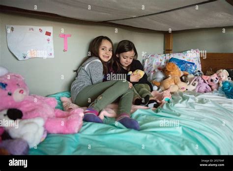 Two Young Sisters Playing Together With Stuffed Animals On Bunkbed