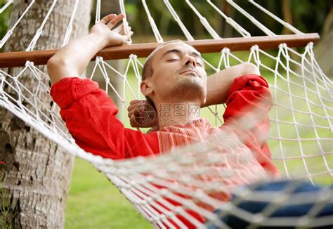 迷人的年轻男子躺在吊床上在热带家庭花园里高清图片下载 正版图片504748548 摄图网