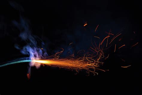 Burning Fuse With Sparks And Blue Smoke On Black Background Photograph