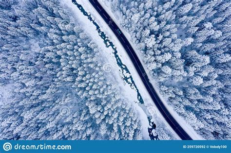 Aerial View On A Car Driving On Winter Country Road In Snowy Forest