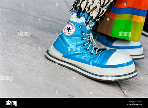 A Clown Wears Oversized Cyan Converse Sneakers During The Clown
