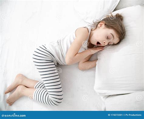 A Cute Little Girl Is Sleeping In A White Bed Stock Image Image Of