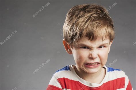 Young Boy Looking Angry Clenching Teeth Against Gray Background