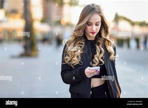 Blonde Frau Sms Mit Ihrem Smart Phone Im Städtischen Hintergrund