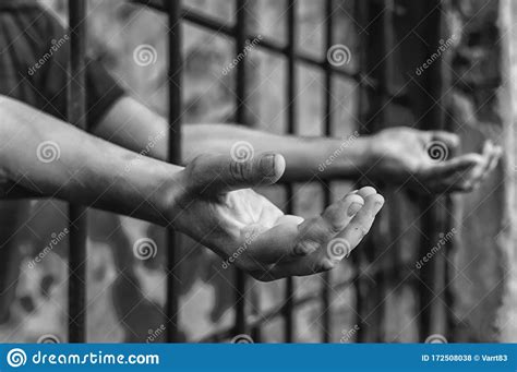 A Depressed Man In Handcuffs Behind Bars A Depressed Arrested Male Offender Is Jailed Stock