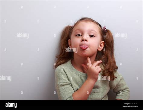 Thinking Grimacing Girl Showing Tongue With Finger Under Face And