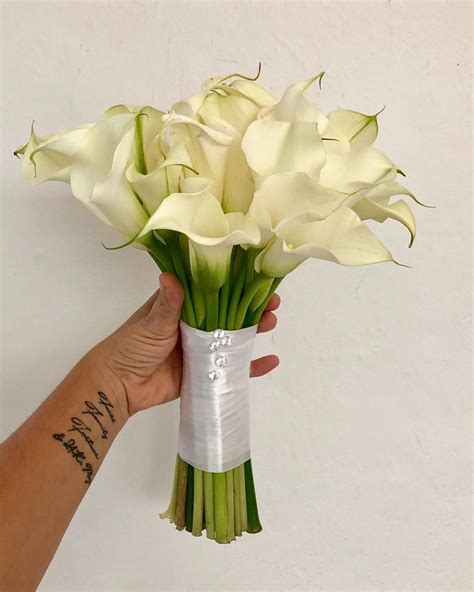 A Hand Holding A Bouquet Of White Flowers