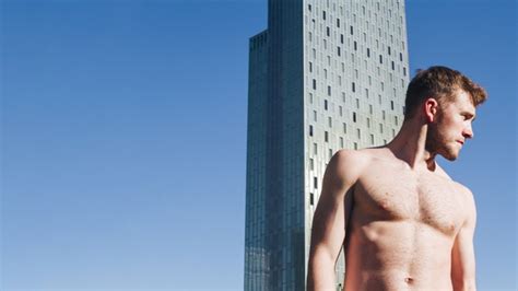 Free Charming Shirtless Man Standing In Front Of Modern Building