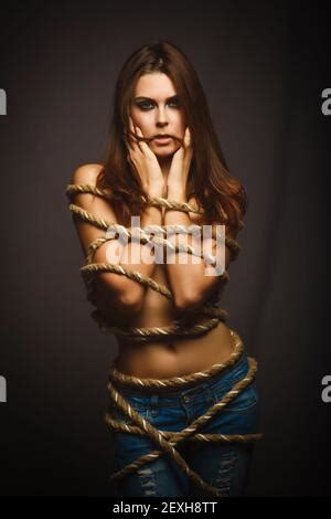 Brunette Woman With Rope Bound Prisoner Hostage Stands Sideways Stock Photo Alamy