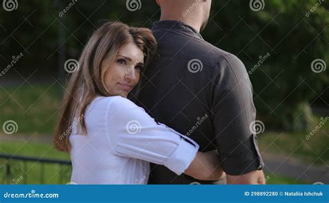 A Woman Approaches Her Beloved Man From Behind And Gently Hugs Him With