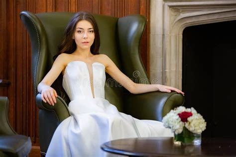 Portrait Of A Beautiful Girl Wearing White Wedding Dress Sitting At The