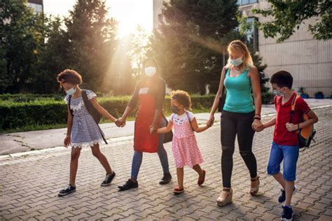 A Group Of Happy Teachers Walking In A School Corridor Stock Photos