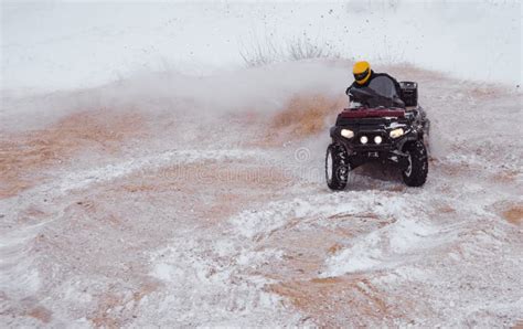 A Motorcyclist On An Atv Rides Off Road In A Snowy Winter Forest