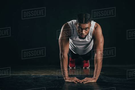 Young African American Sportsman Doing Plank Position And Looking At