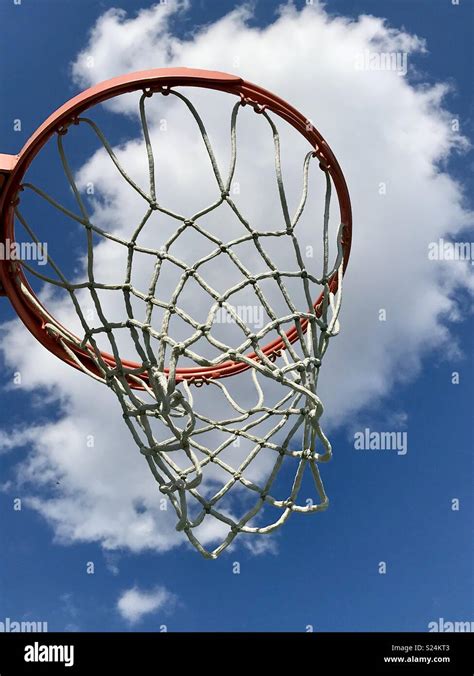 Basketball Hoop And Net Against A Deep Blue Sky And White Cloud