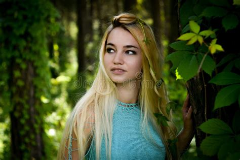 Pretty Young Blonde Girl With Long Hair In Turquoise Dress Standing In