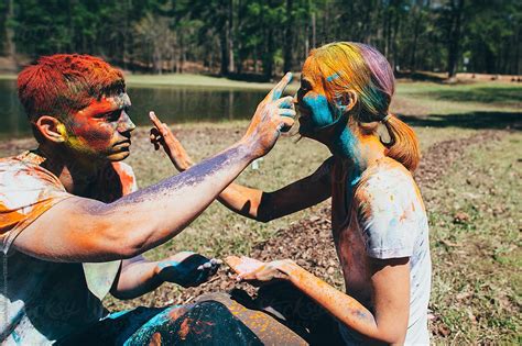 couple throwing colored holi powder at each other for fun by stocksy contributor michelle