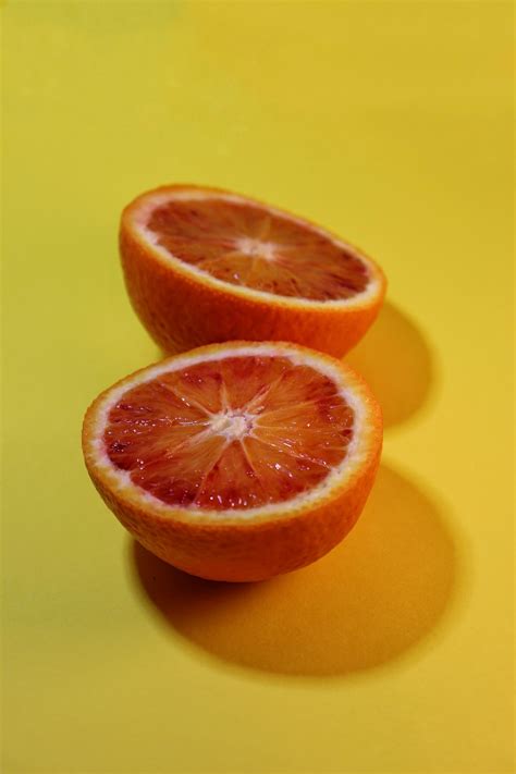 Sliced Orange Fruit On Yellow Surface Photo Free Citrus Fruit Image