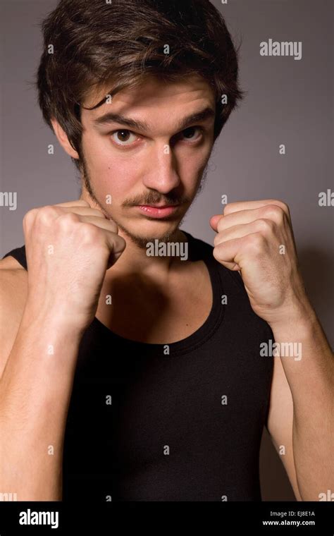 Studio Portrait Of A Handsome Young Man Showing His Fists Stock Photo