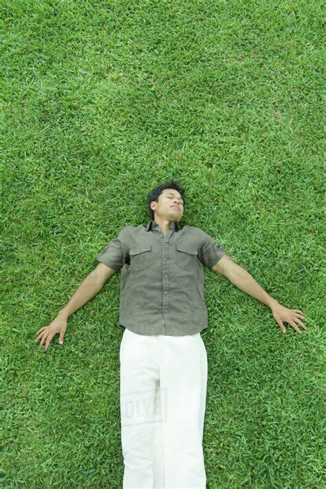 Man Lying On Back In Grass Eyes Closed Full Length