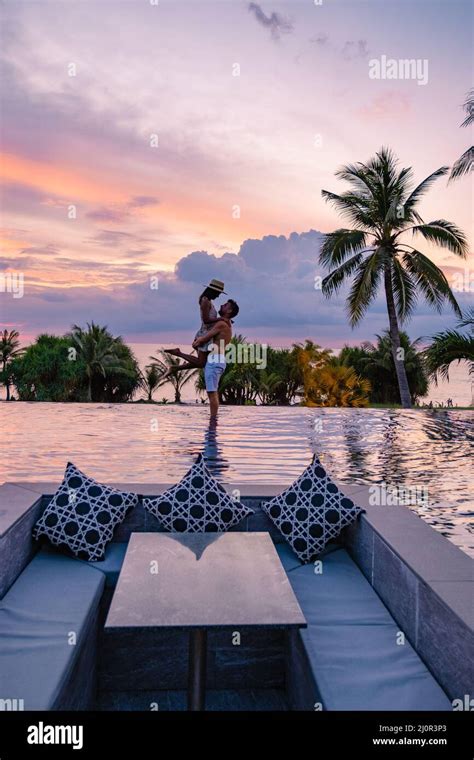 couple watching sunset in infinity pool on a luxury vacation in thailand man and woman watching